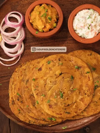 Our Masala Chapathi is a spiced whole wheat flatbread, served here with raita and a vegetable side dish. It's a flavorful alternative to plain roti.