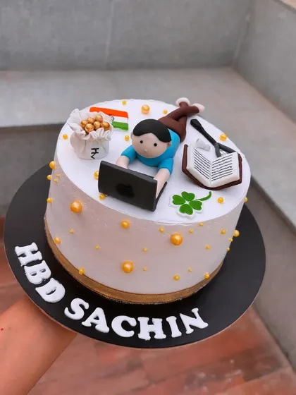 A personalized cake showing all of someone's favorite things: their laptop, badminton, the Indian flag, and money.