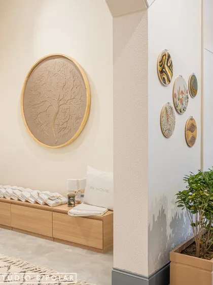 Art and decor are integrated thoughtfully into the FA Home store. A large, circular textured art piece and smaller, embroidered hoops on the wall serve as subtle nods to the brand's focus on craftsmanship and artistry.