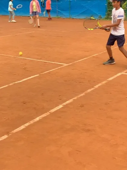 A young player practices his forehand during a group session. We focus on teaching correct form and technique from an early age.