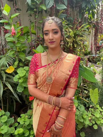 A full-length view of the first look. The makeup, hair, and styling all come together to create a stunning, traditional South Indian ensemble.