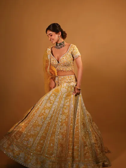 A full-length shot showing the beautiful twirl of the lehenga. The makeup is designed to look stunning both up close and from a distance.