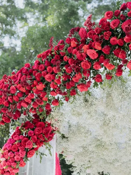 A stunning floral arch made of red roses and baby's breath, a dramatic and romantic decor element.