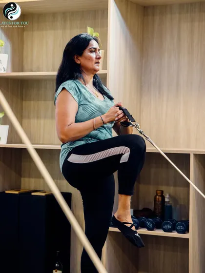 It's never too late to start your fitness journey. This client is working on her leg strength and stability, proving that Pilates is a safe and effective workout at any age.