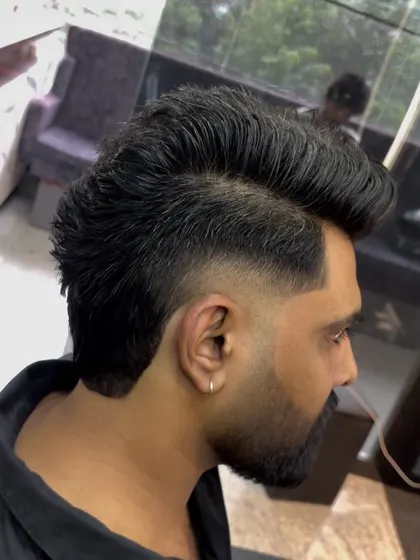 A pompadour-mullet hybrid, also known as a "pompa-mullet". This style combines the volume of a pompadour at the front with the length of a mullet at the back.
