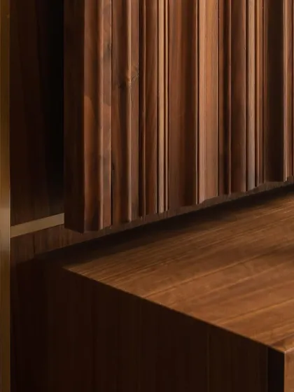 The beauty of this wooden console lies in its intricate details. The combination of smooth surfaces, fluted panels, and fine metal inlays whispers a story of timeless elegance and expert craftsmanship.