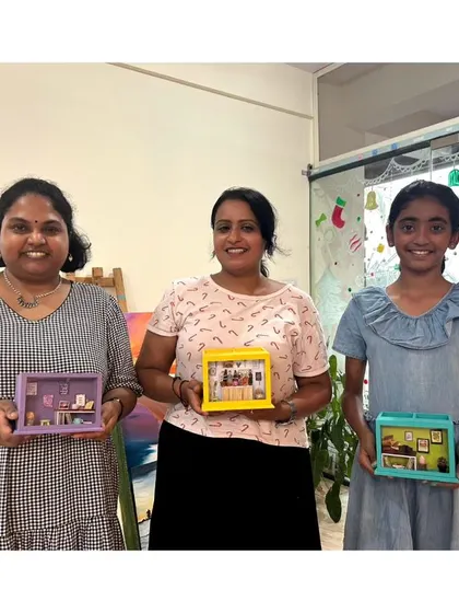 A group of participants holding the incredible miniature shadow boxes they created in a workshop.