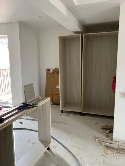 An in-progress shot of a kitchen renovation, showing the empty cabinet carcasses before the doors and finishes are applied.
