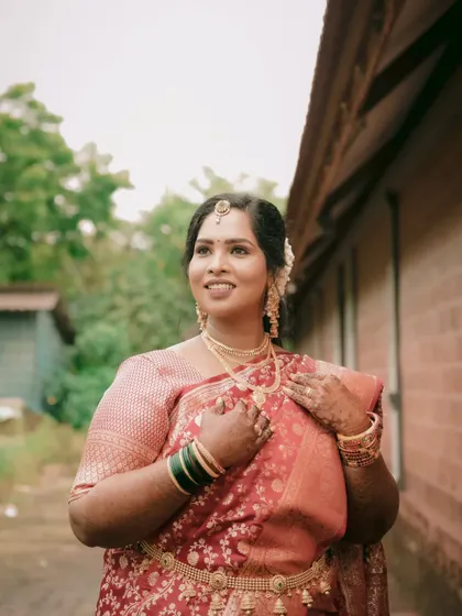 A lovely portrait of the bride looking away with a hopeful expression. The natural outdoor lighting enhances the rich color of her saree.