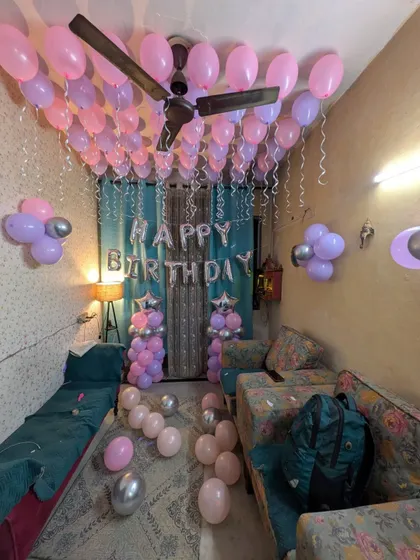 The room is filled with scattered balloons on the floor and balloon clusters on the walls, creating a fun and immersive experience.