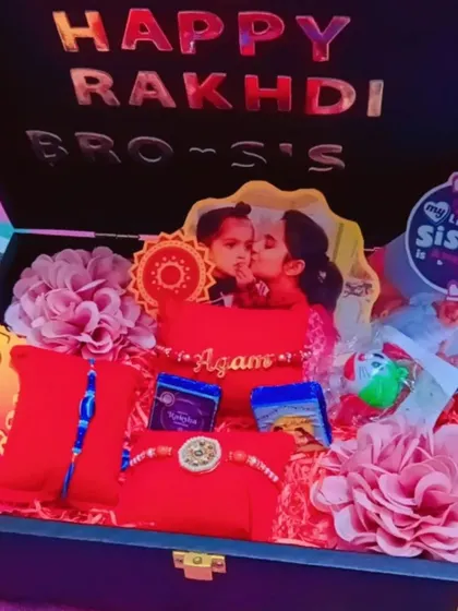 Another view of a packed Rakhi gift trunk, this one for a brother and sister, showing custom pillows and photos.