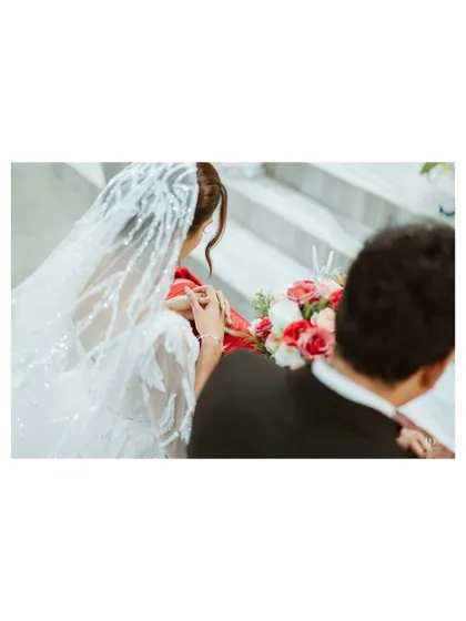 An over-the-shoulder shot of the bride and groom, focusing on their joined hands and the bride's beautiful bouquet. This angle creates a sense of intimacy and shared experience.
