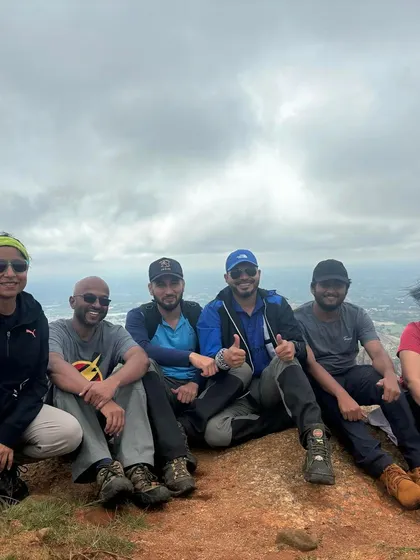 Taking a break at the summit with panoramic views of the city in the distance. These moments of quiet reflection are a valuable part of the outdoor experience.