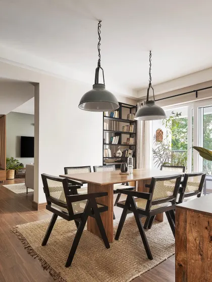 The full dining setup एट 'Ikigai Living'. The design is simple yet elegant, with a focus on natural materials like wood, cane, and jute to create a warm and inviting atmosphere.