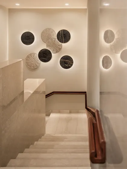 Transitional spaces matter. The staircase at the Elevate Clubhouse is adorned with backlit, textured wall art, transforming a simple stairwell into a memorable design feature that guides movement and delights the eye.