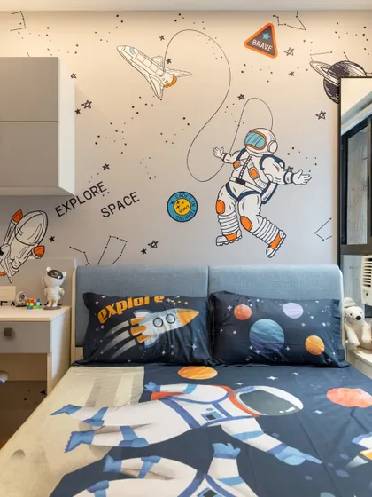Another view of the space-themed room, highlighting how the wallpaper, bedding, and a full-length mirror come together to create an immersive and fun environment.