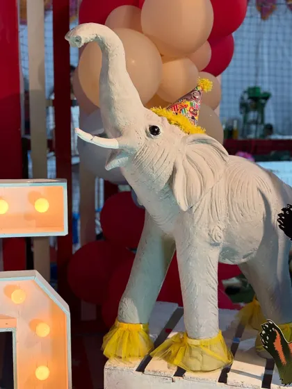 An adorable elephant prop wearing a party hat, adding to the whimsical and festive atmosphere of the circus celebration.