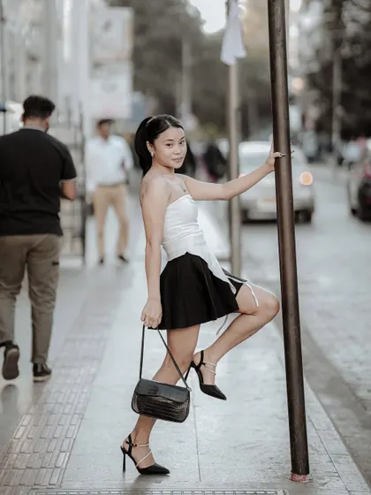 This shot captures a playful and confident pose on a city sidewalk. It's a great example of how to create engaging fashion images in everyday locations.
