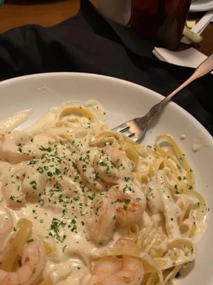 A close-up of a creamy shrimp Alfredo pasta, one of the continental dishes I offer for private dinner parties. The dish is garnished with fresh parsley, ready to be enjoyed.