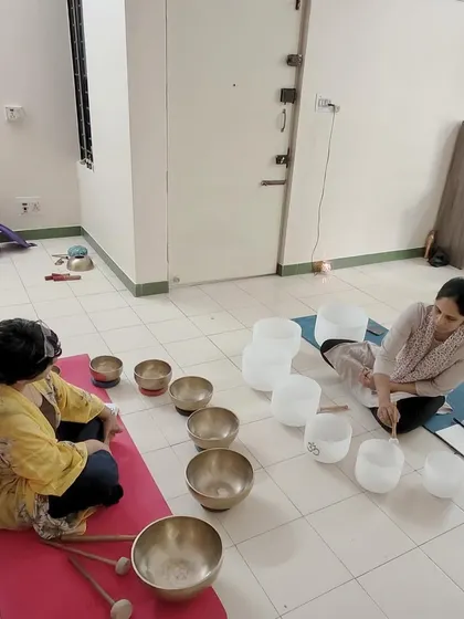 Students work together during a practical training session, exploring the different sounds of Tibetan and crystal singing bowls. This collaborative learning environment is key to building the skills needed to facilitate sound baths.