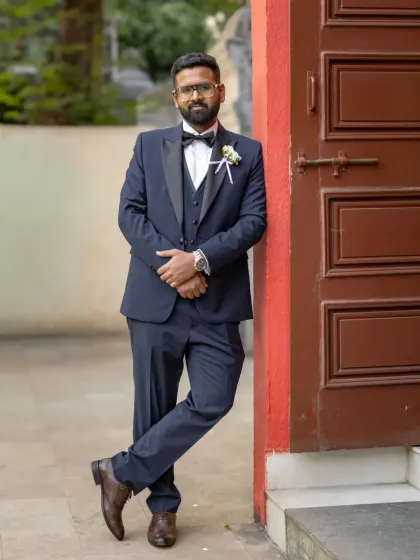 A cool and confident portrait of the groom, leaning against a doorway. A simple pose can often be the most effective for a stylish shot.