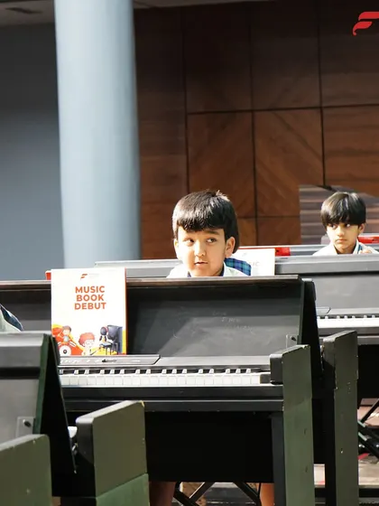 A young student peeks over his keyboard, ready for his performance at the CSN School recital. We create a supportive atmosphere where even the youngest performers feel comfortable on stage.