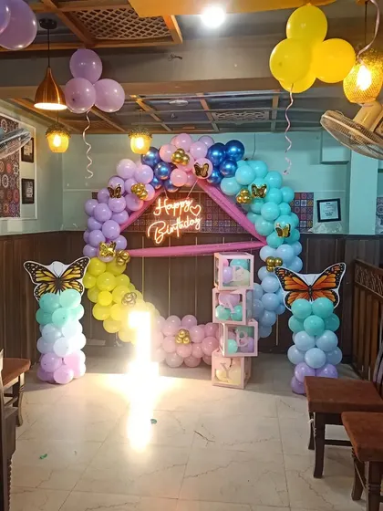 A butterfly-themed decoration set up in a restaurant space. I can work with any venue to create a beautiful party corner, complete with a balloon arch and light-up props.