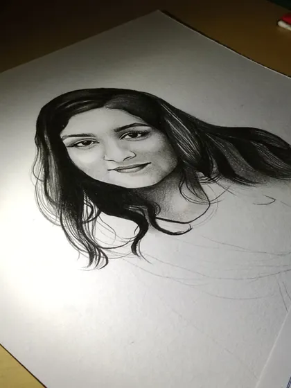 A work-in-progress shot of a commission. You can see how I build up the layers of graphite to create realistic hair and facial features.