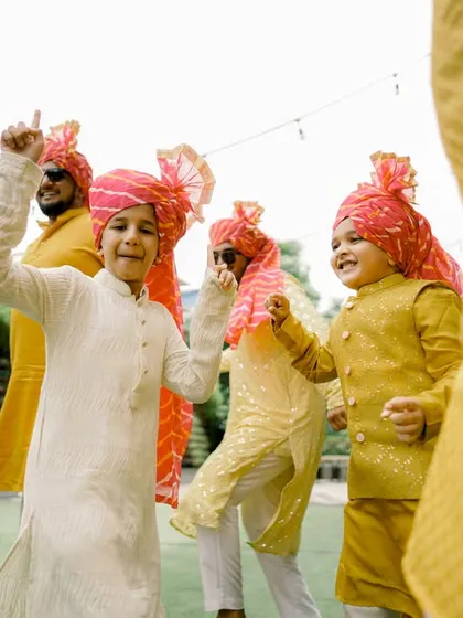 The youngest members of the wedding party dancing with enthusiasm, their colorful turbans adding to the festive scene.