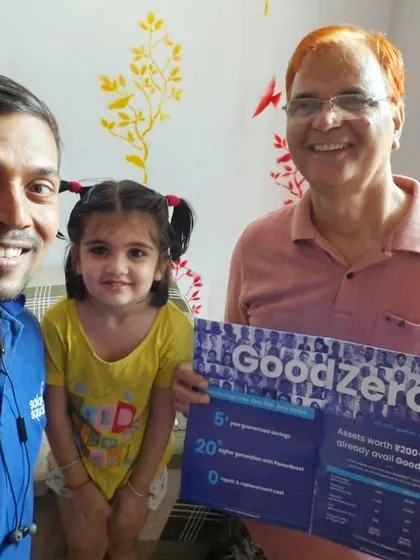 A young girl holds our "GoodZero" brochure while her family finalizes their solar plan with our team. The future of solar is bright.