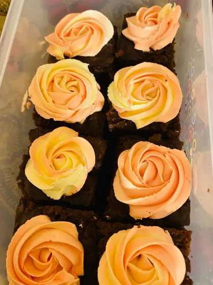 A box of my moist chocolate cake squares with dual-toned rosettes, ready to be delivered for a special event.
