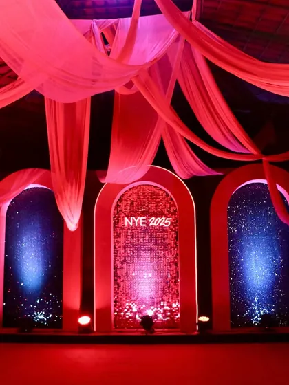 A stunning stage backdrop featuring three arched doorways with glittering panels, all bathed in dramatic red and blue light.