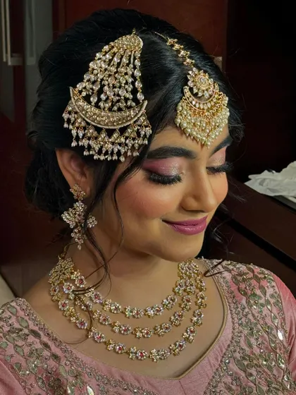 A gentle smile from the bride. This close-up shows the flawless base makeup, the blended eyeshadow, and how the jewellery frames her face perfectly.