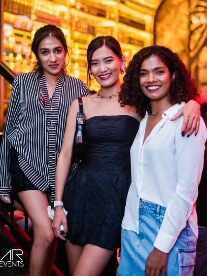 Three stylishly dressed friends posing for a photo.