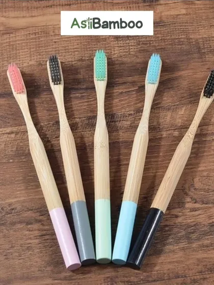 A close-up of our bamboo toothbrushes, showing the different bristle colors available. These are ideal for hotels, resorts, and corporate wellness initiatives.