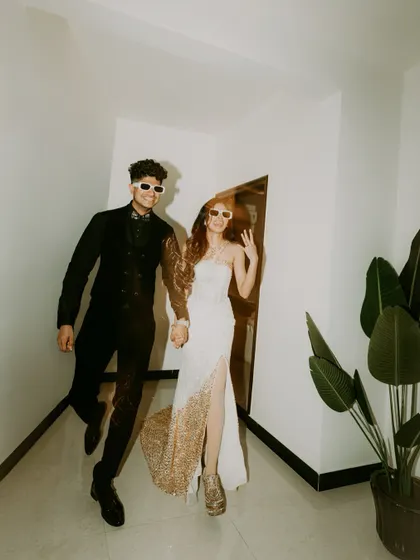 The couple makes a fun and stylish entrance in sunglasses, ready for the after-party.