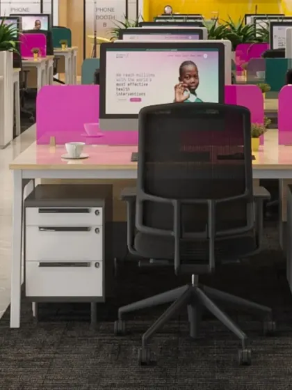 A closer look at the workstation setup, showing ergonomic chairs, ample desk space, and personal storage units. The design prioritizes employee comfort and efficiency.