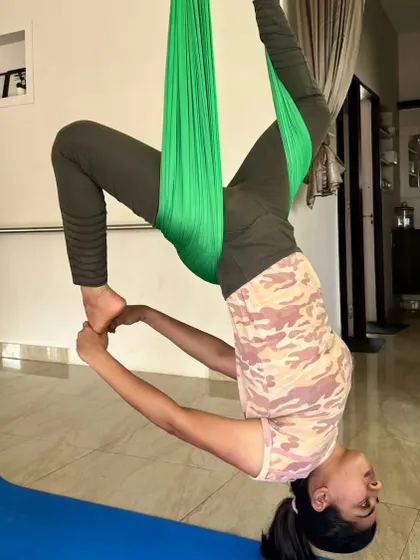 Finding a moment of serenity in an aerial yoga inversion. This pose helps to calm the mind while gently stretching the spine.
