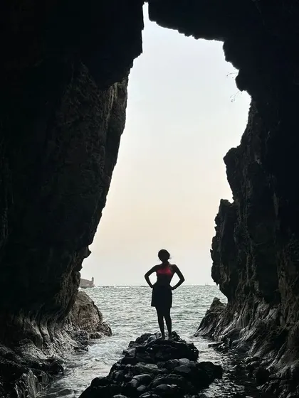A powerful silhouette shot from inside a sea cave in Goa. This adventurous photo creates a dramatic and inspiring image, perfect for travel and exploration themes.