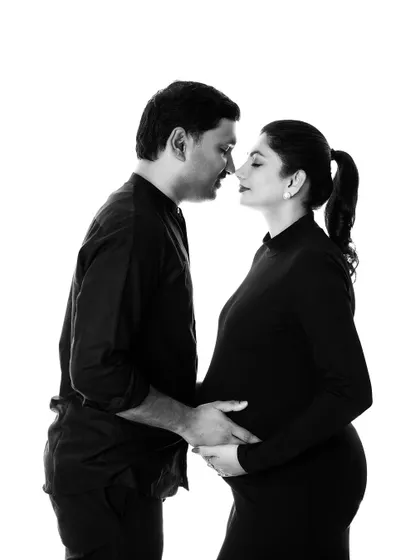 A timeless black and white portrait of the couple. The simple background and classic pose put all the focus on their emotional connection.