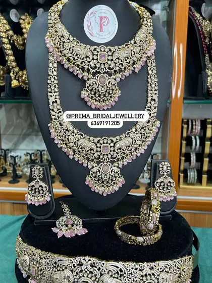 A full bridal combo with pink stones and elephant motifs on the vaddanam.