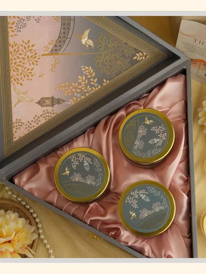 The "Grey Delight" hamper features a triangular box with an elegant design. Inside, the satin lining holds three matching jars, creating a unique and stylish gift.
