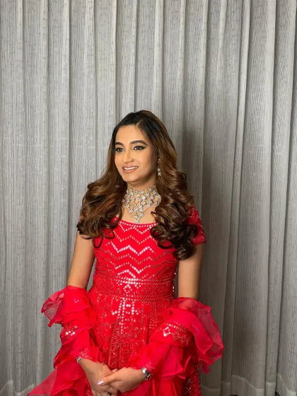 The side-parted voluminous curls add a touch of Hollywood glamour, perfect for a cocktail night or reception.
