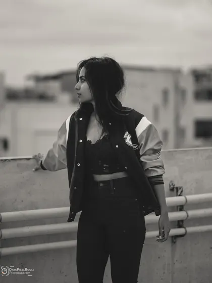 This black and white urban portrait has a raw, documentary feel. The rooftop setting and the subject's direct gaze create a powerful image that feels both candid and composed.