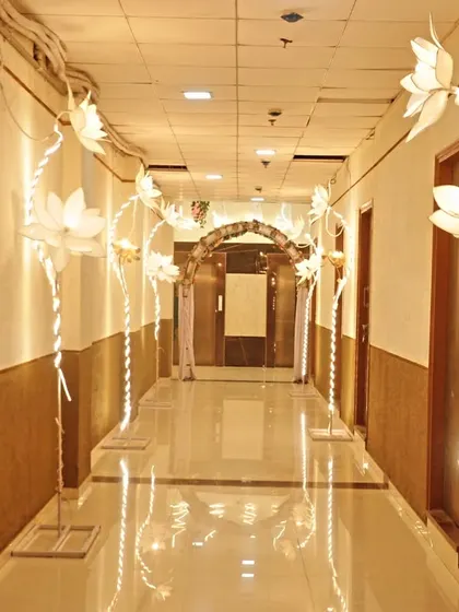 The beautifully lit corridor of our Badlapur banquet hall, decorated with illuminated lotus props to welcome your guests.