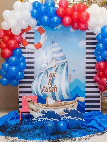 A nautical-themed photo booth for the travel party, complete with a ship, anchor, and 'Welcome Aboard' signs.