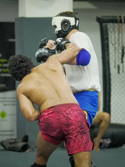 Two fighters locked in a grueling clinch exchange during sparring. This is about strength, technique, and the will to dominate.