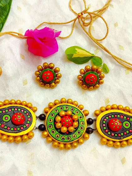 A stunning choker necklace with paisley and circular motifs in green and red.