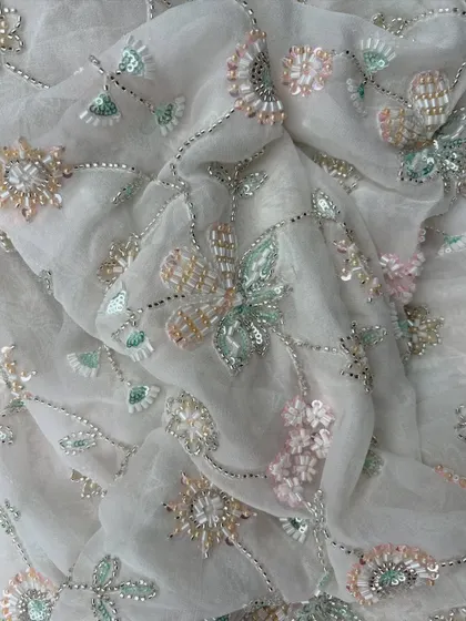 A stunning example of our embroidered georgette, with pastel-colored floral embroidery and silver beadwork that creates a sparkling, ethereal effect.