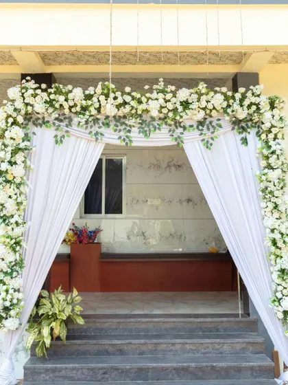 The entrance to the engagement ceremony was decorated with a simple and elegant arch of white florals and drapes, setting a graceful tone for the event.